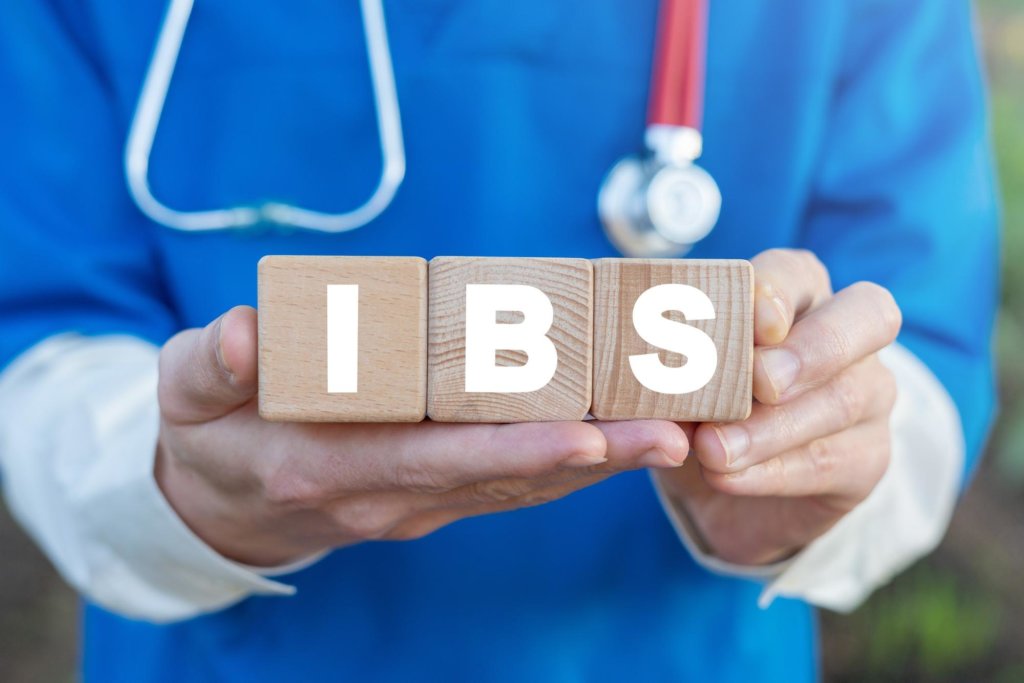 A doctor holding blocks that spell out IBS