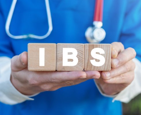 A doctor holding blocks that spell out IBS