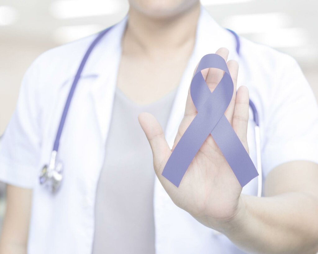 A healthcare worker holding a purple awareness ribbon to represent the risk factors for stomach cancer